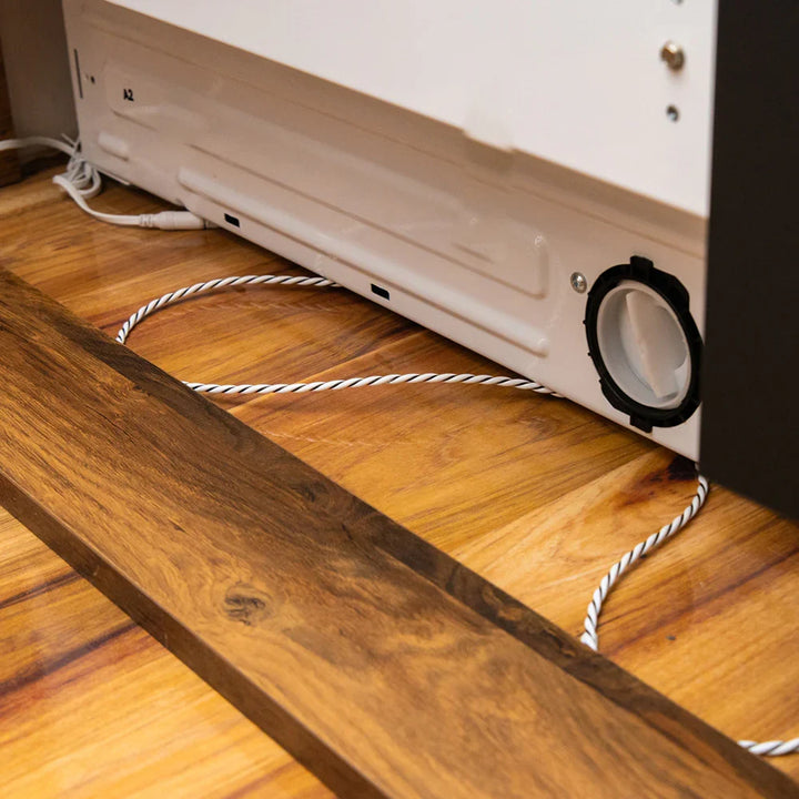 Cable sensor de fugas colocado bajo un electrodoméstico para detectar agua